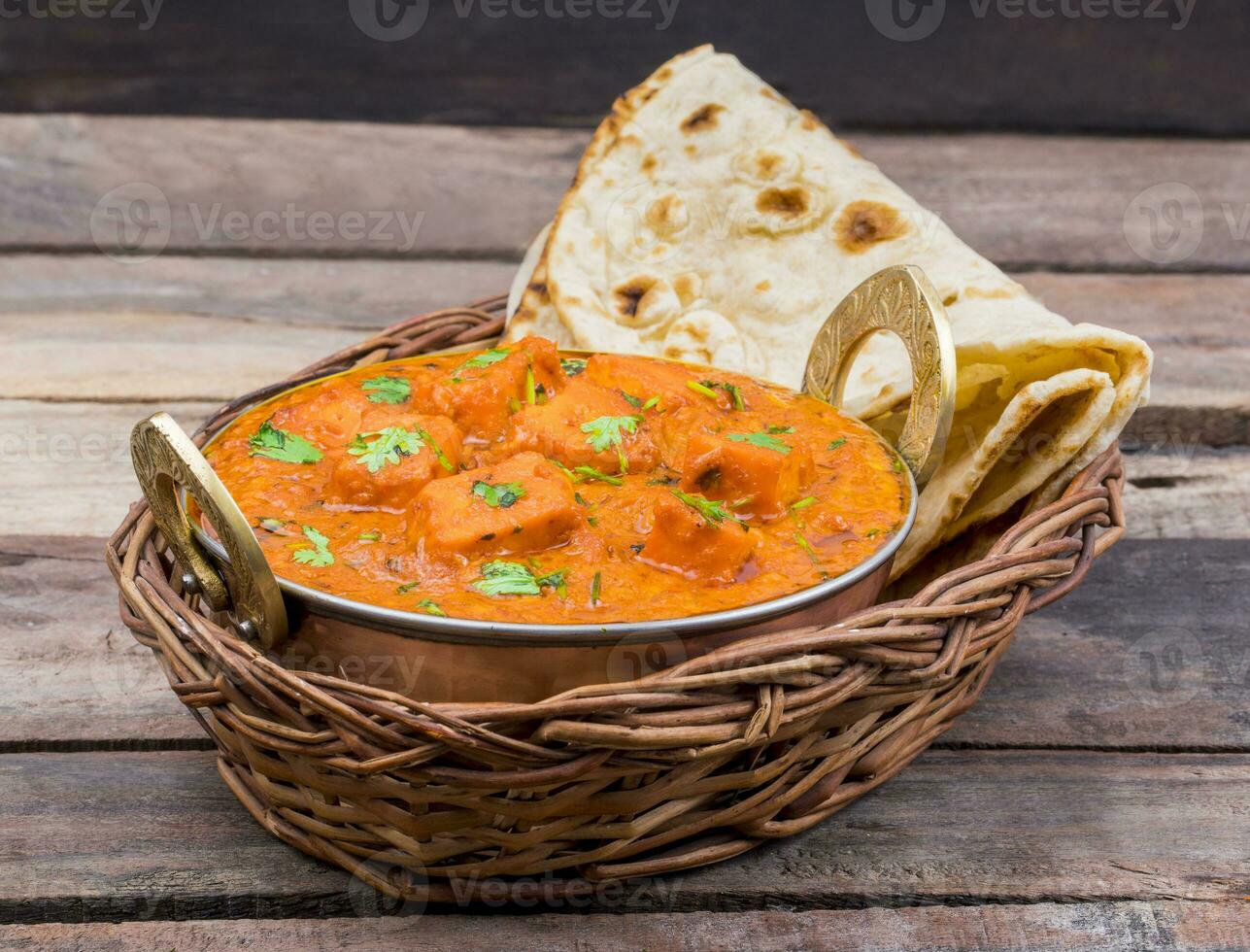 indisk utsökt kök paneer tikka masala med tandoori chapati på trä- bakgrund foto
