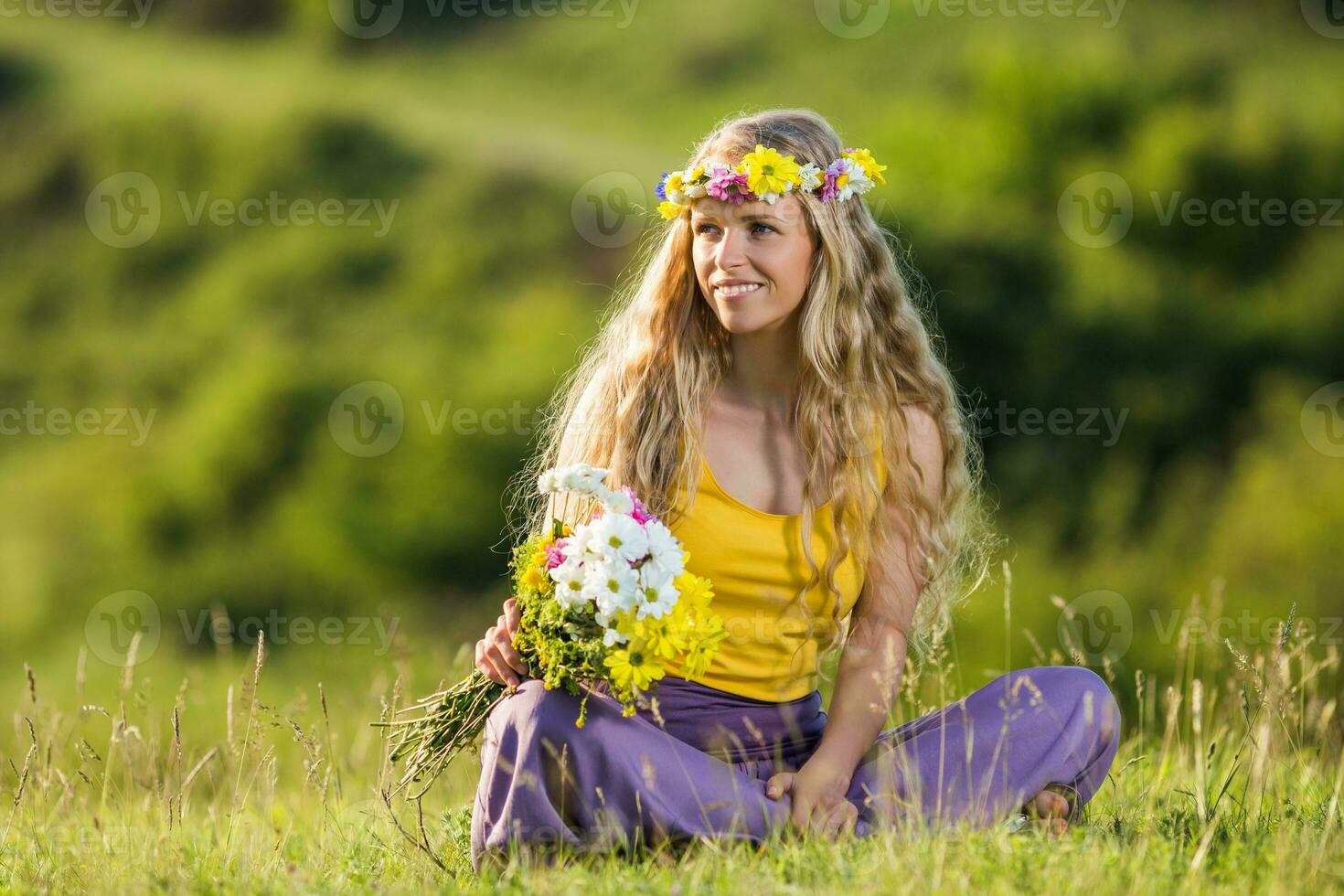 kvinna med krans i henne hår innehav blommor i natur. foto