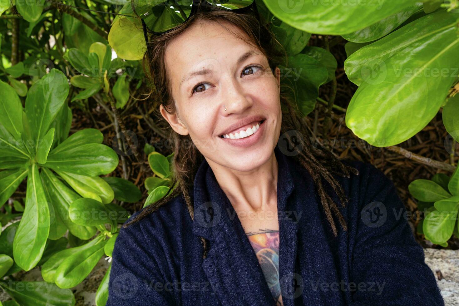 rolig leende kvinna tar selfies bland tropisk löv. foto