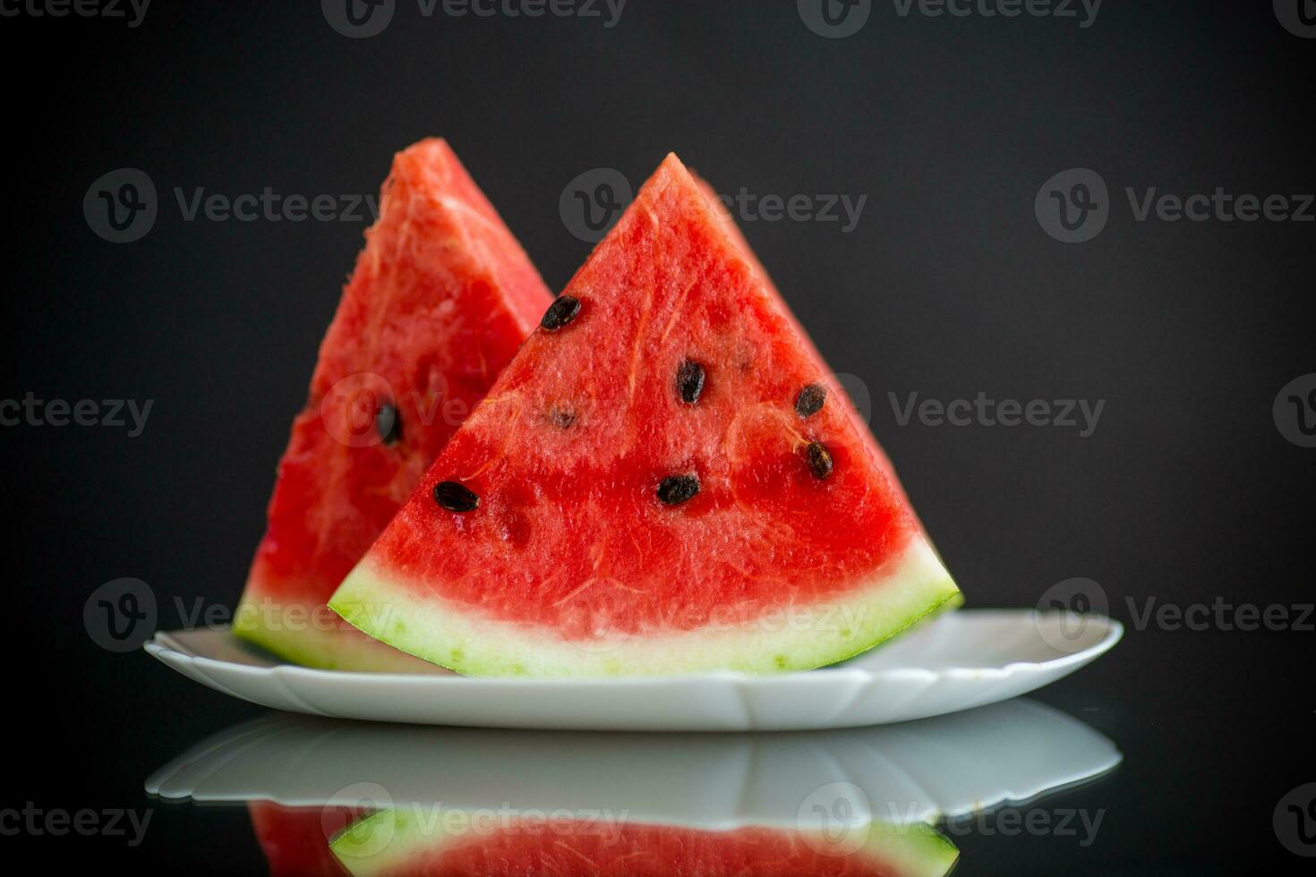 bitar av färsk mogen röd vattenmelon på svart foto