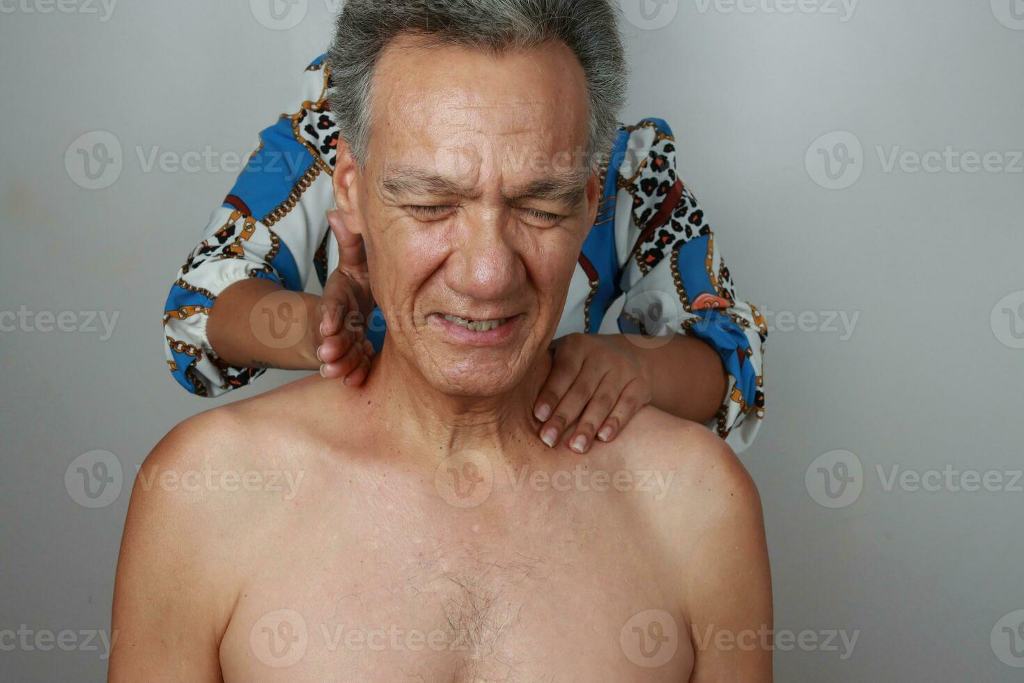 äldre mogna man har en massage på hans övre tillbaka och nacke för smärta lättnad foto