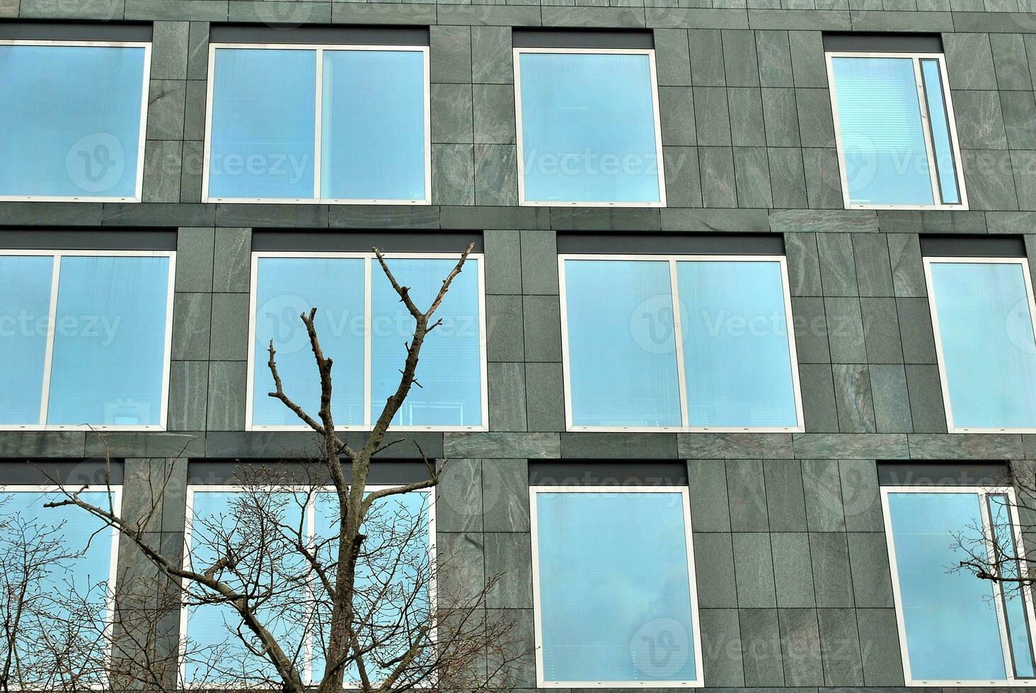 modern kontor byggnad i de stad med fönster och stål och aluminium paneler vägg. samtida kommersiell arkitektur, vertikal konvergerande geometrisk rader. foto