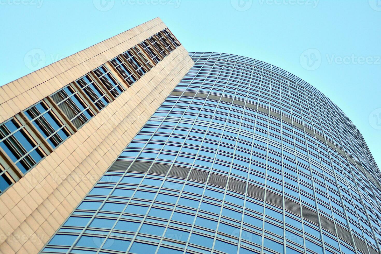 glas byggnad med transparent Fasad av de byggnad och blå himmel. strukturell glas vägg reflekterande blå himmel. abstrakt modern arkitektur fragment. samtida arkitektonisk bakgrund. foto