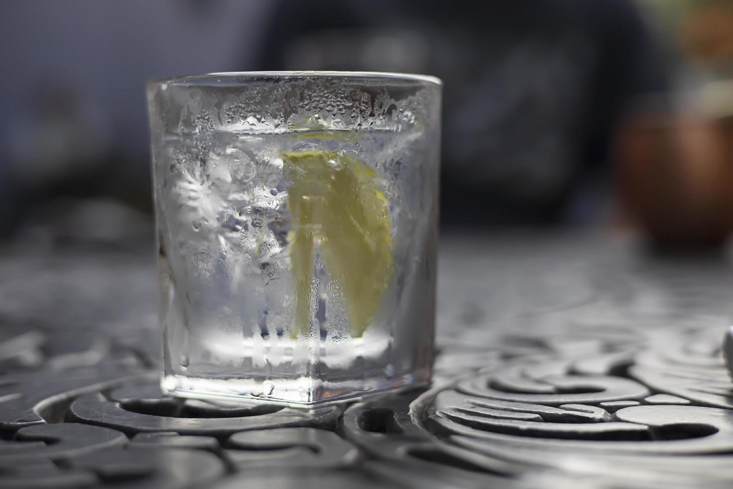 iskall gin och tonic i ett glas på ett bord foto