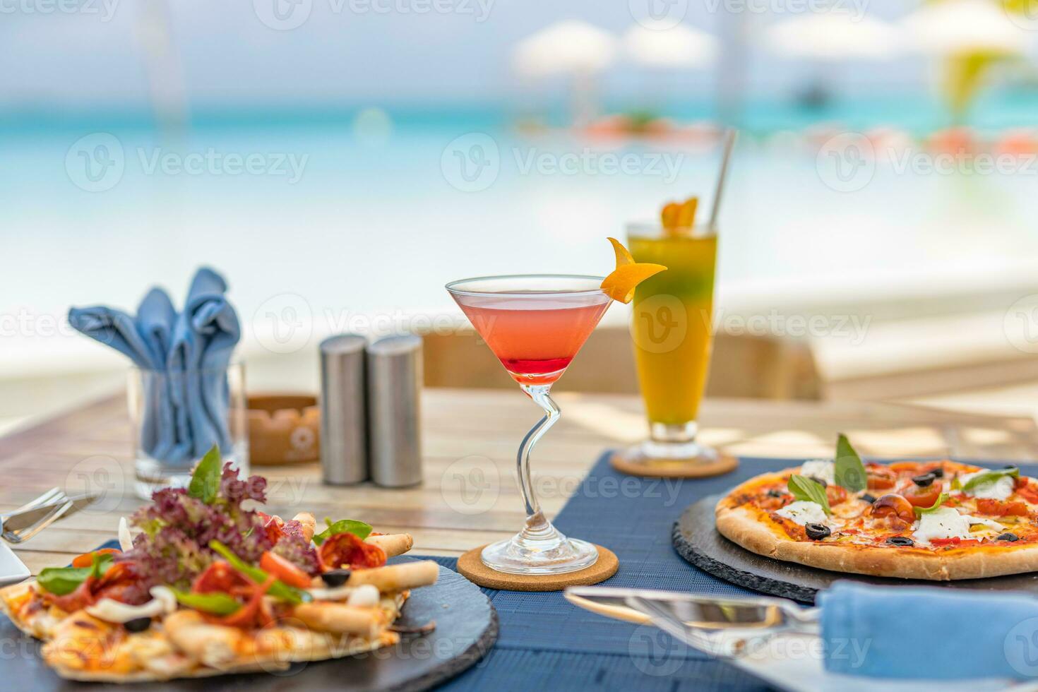 pizza och tropisk cocktail med skön solig semester oändlighet simning slå samman hav se. strand restaurang, hav se, glasögon, tallrikar, mat, tropisk cocktail, fläck solstolar, stolar, Sol paraplyer foto