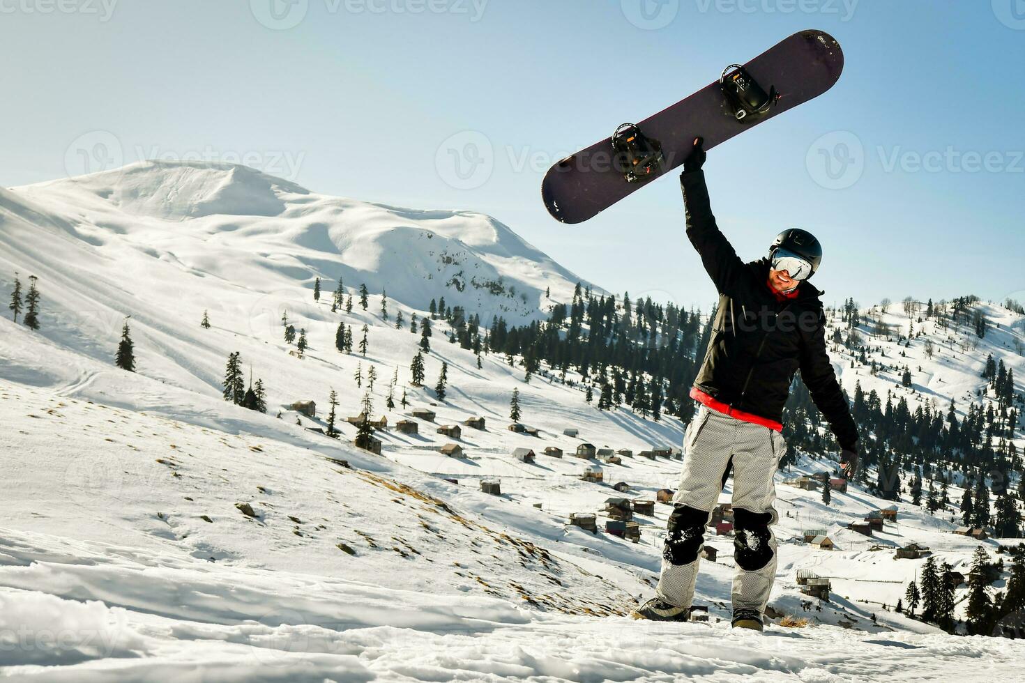 snowboardåkare innehav hans snowboard över huvud i åka skidor tillflykt upphetsad på Semester semester solo- foto