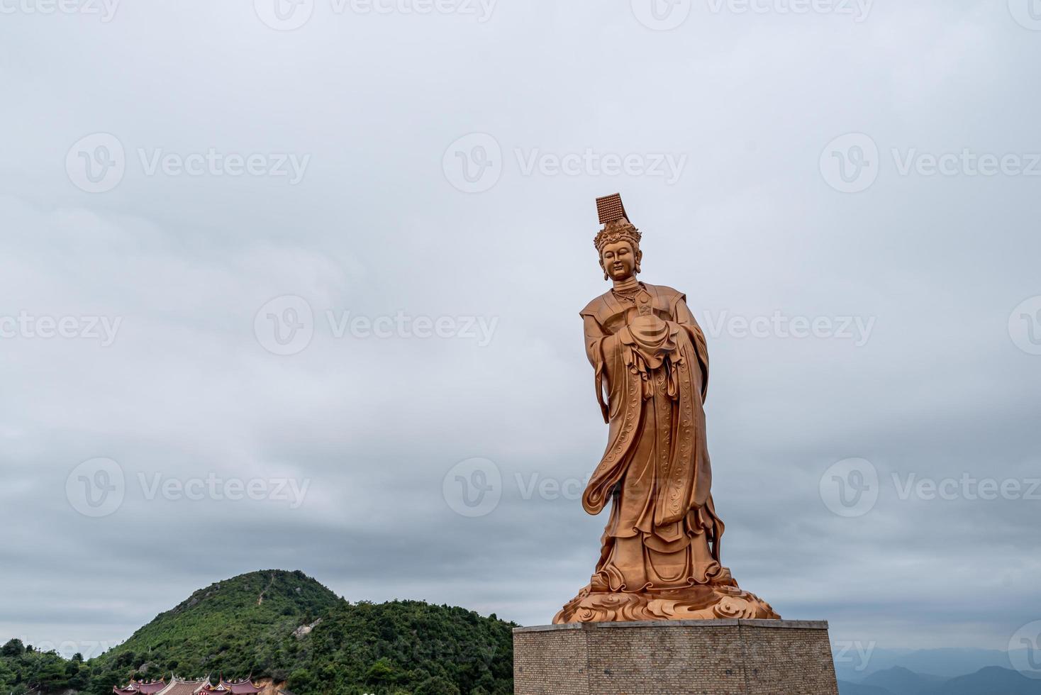 bronsstatyn av den kinesiska religiösa gudinnan i grumligt väder foto