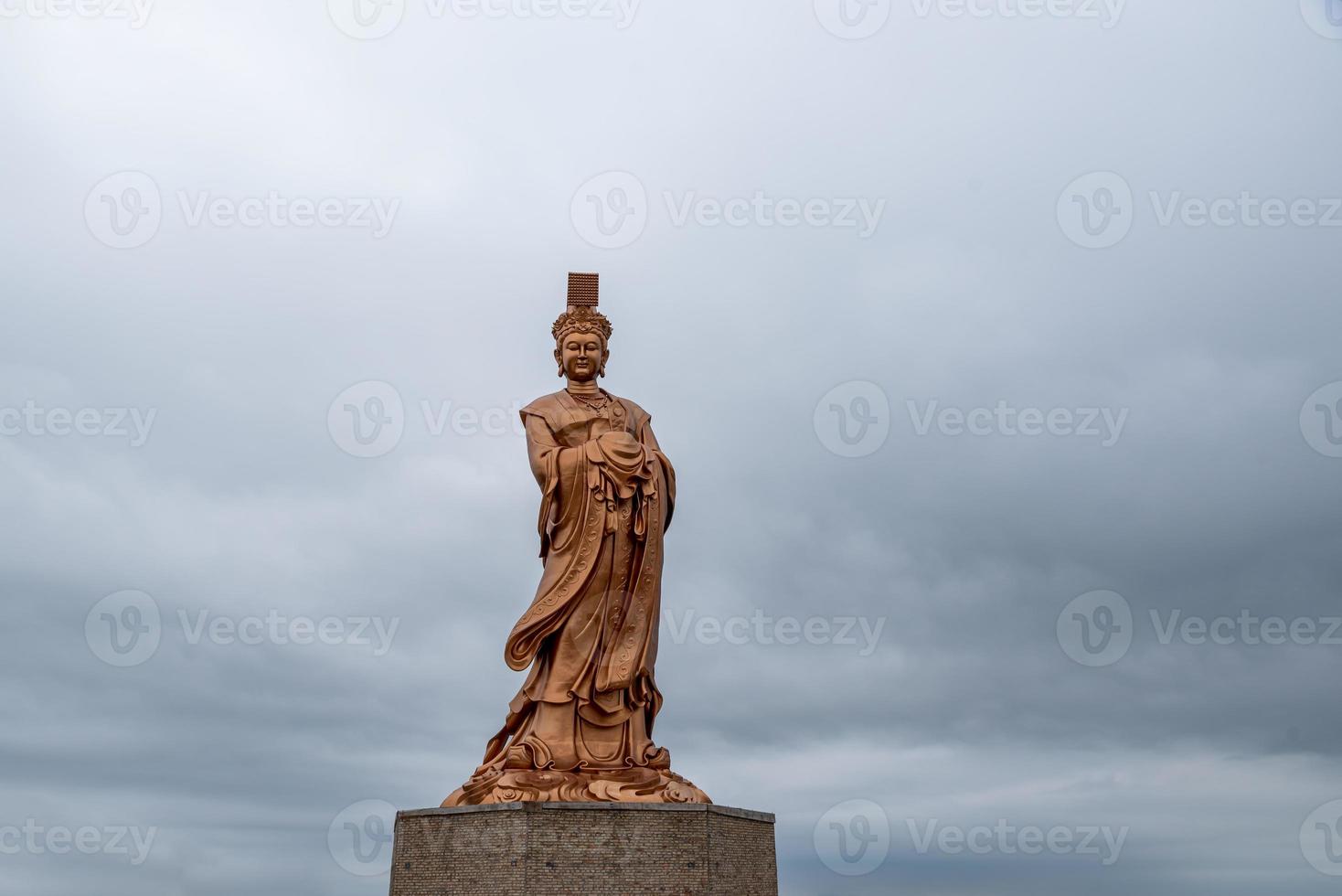 bronsstatyn av den kinesiska religiösa gudinnan i grumligt väder foto