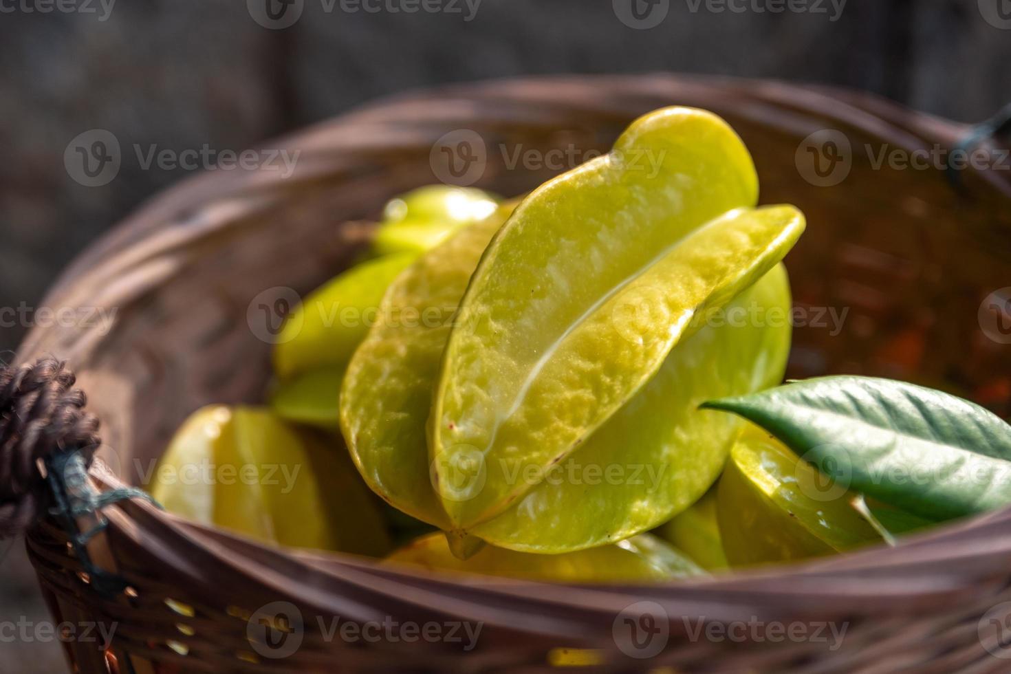 den gula karambolan är mogen. plocka den och lägg den i korgen foto