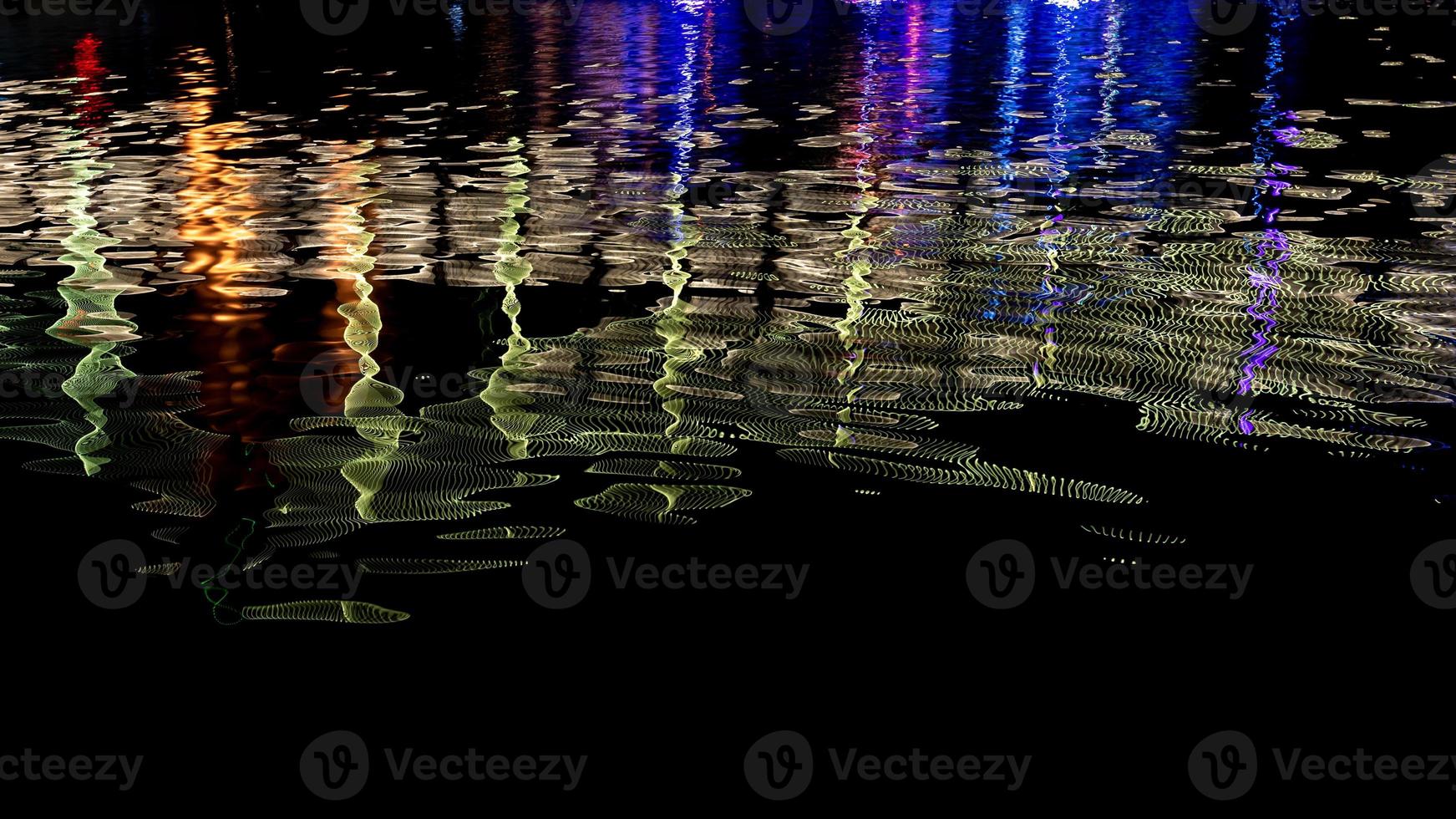 på natten reflekterar bäcken de färgglada ljusen på bron foto