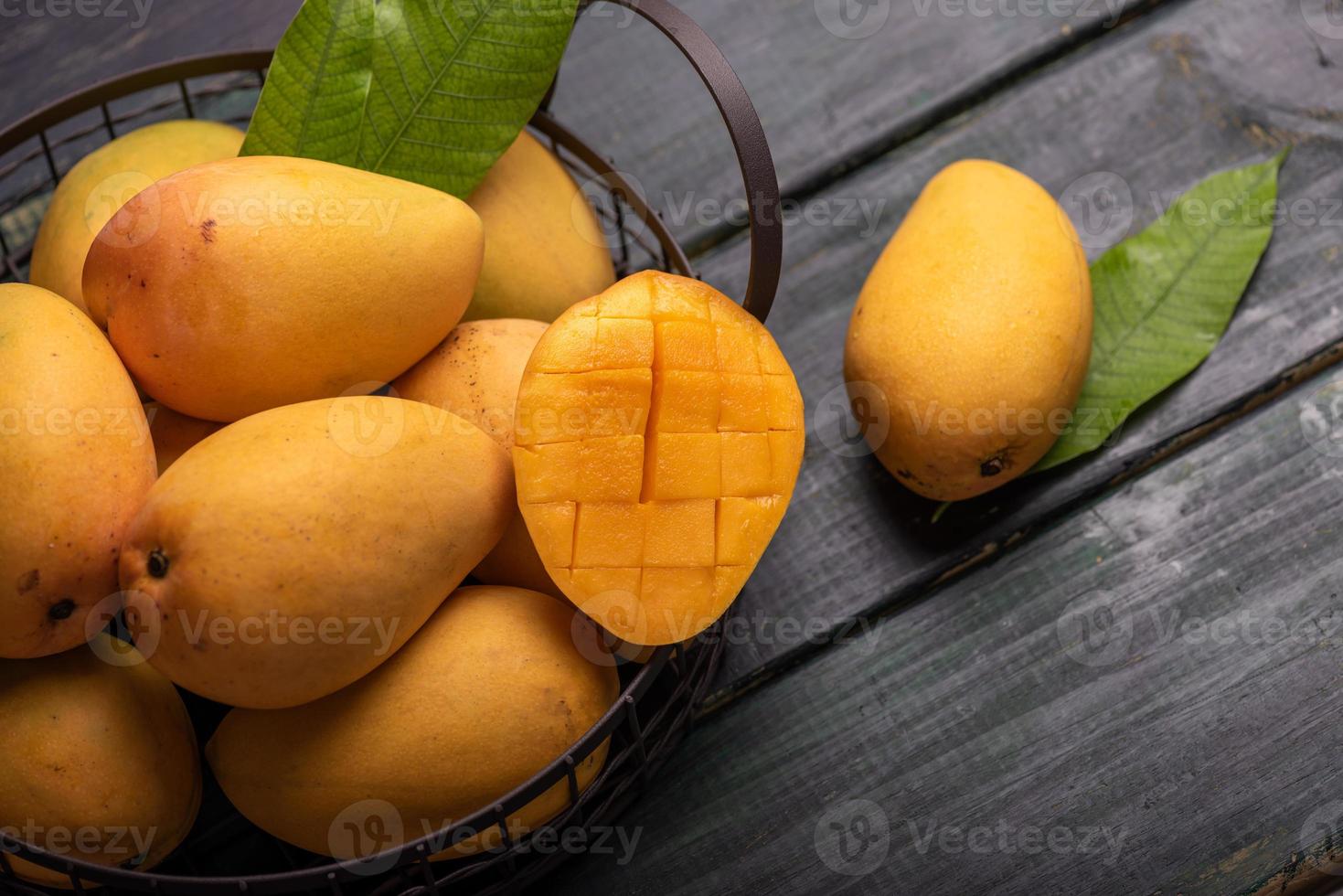 skurna och intakta mango i den mörka bakgrunden foto