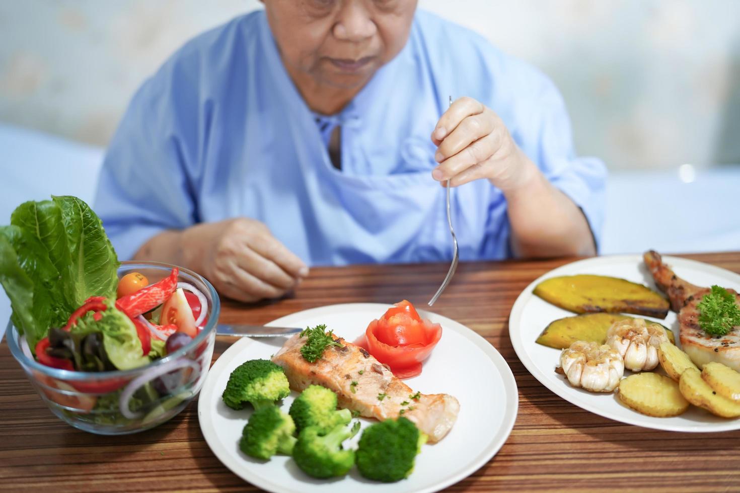 asiatisk senior kvinna patient äter frukost på vårdsjukhus foto