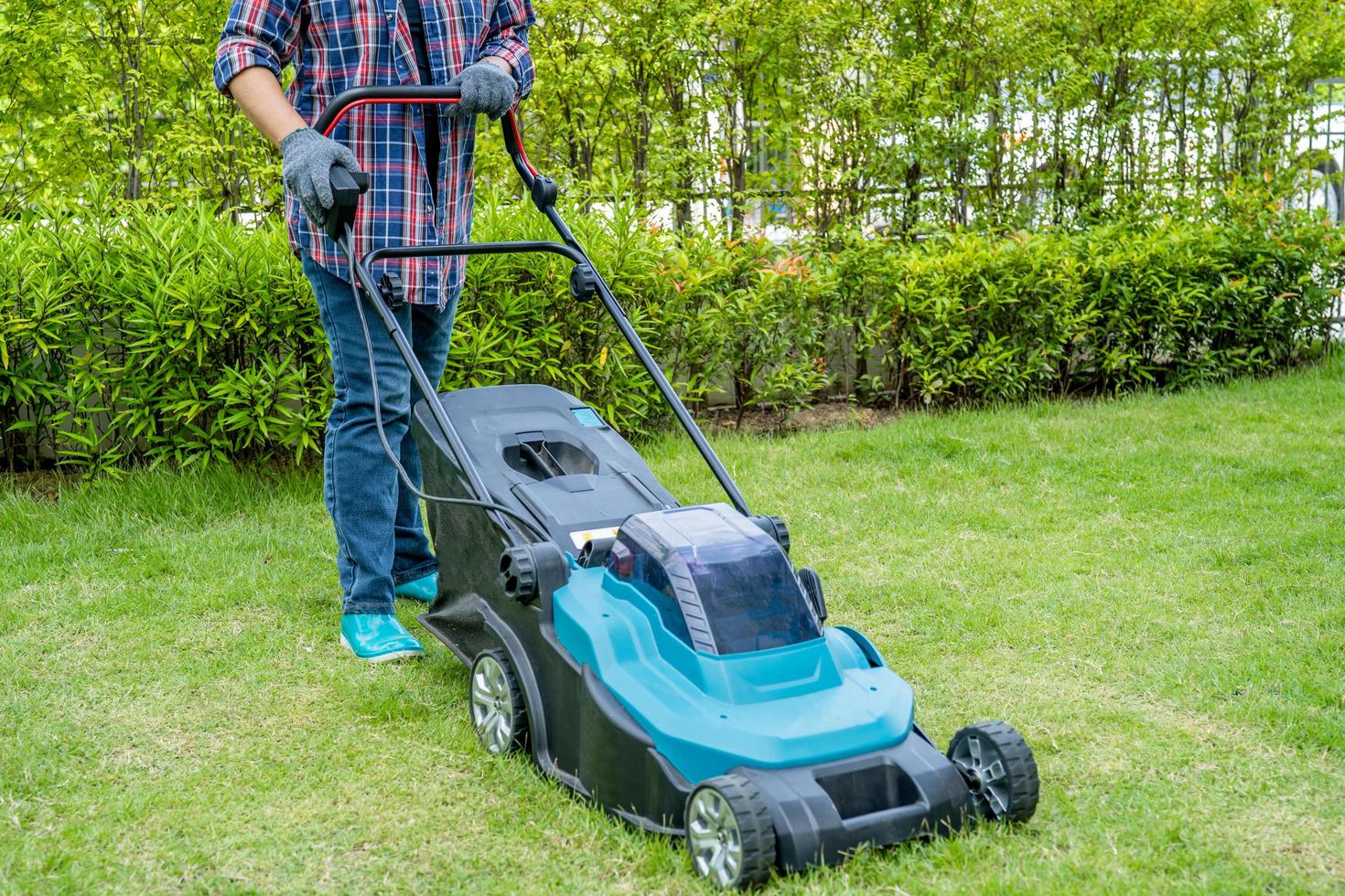 trädgårdsmästare använder gräsklippare maskin klippa grönt gräs, hobby plantera hemträdgård foto