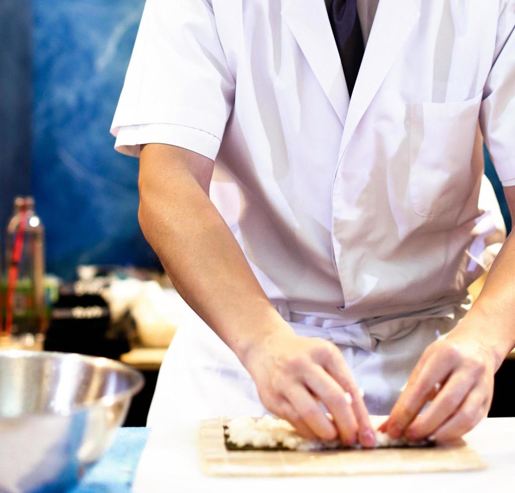 kockhänder som förbereder japansk mat, kock som gör sushi foto