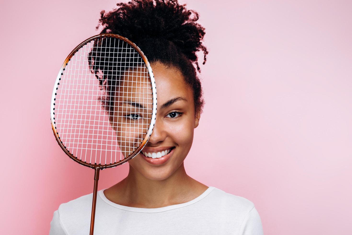 lekfull tjej som håller tennisracket foto