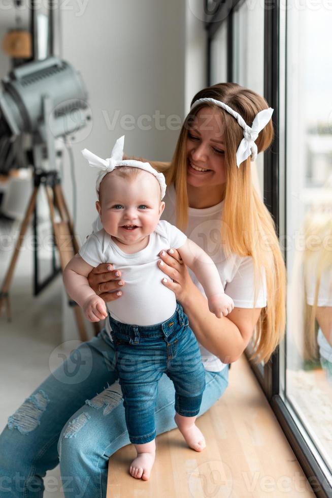 liten vacker flicka i famnen på en ung mamma. foto