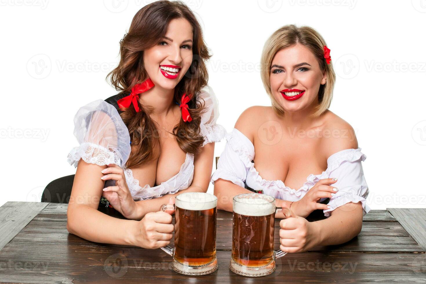 två skön blond och brunett flickor av oktoberfest öl ölkrus foto