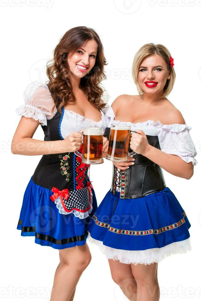 två skön blond och brunett flickor av oktoberfest öl ölkrus foto