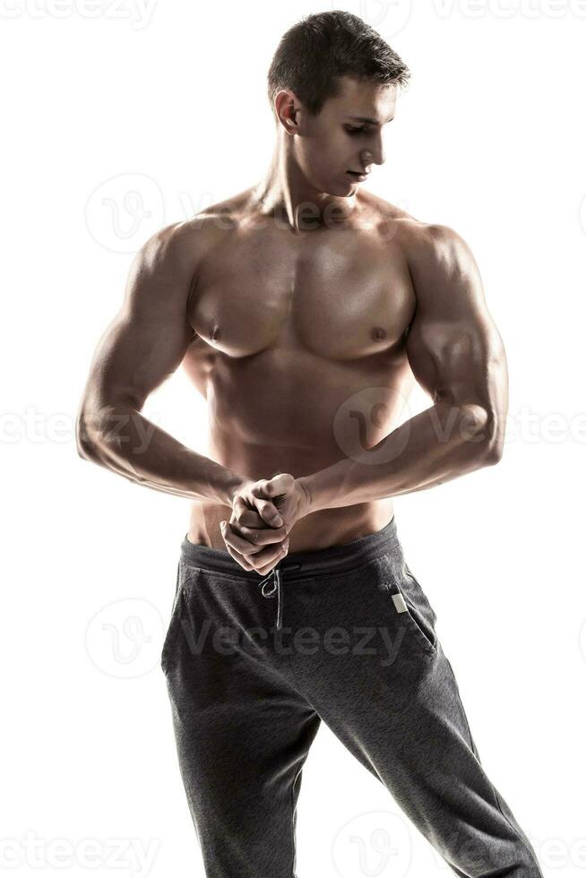 muskulös man poserar, böjning hans biceps, som visar perfekt kropp. foto