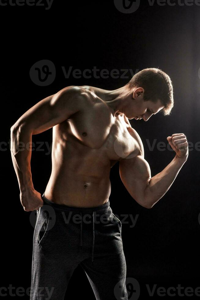 stark man som visar perfekt magmuskler, hållare, biceps, triceps och ch foto