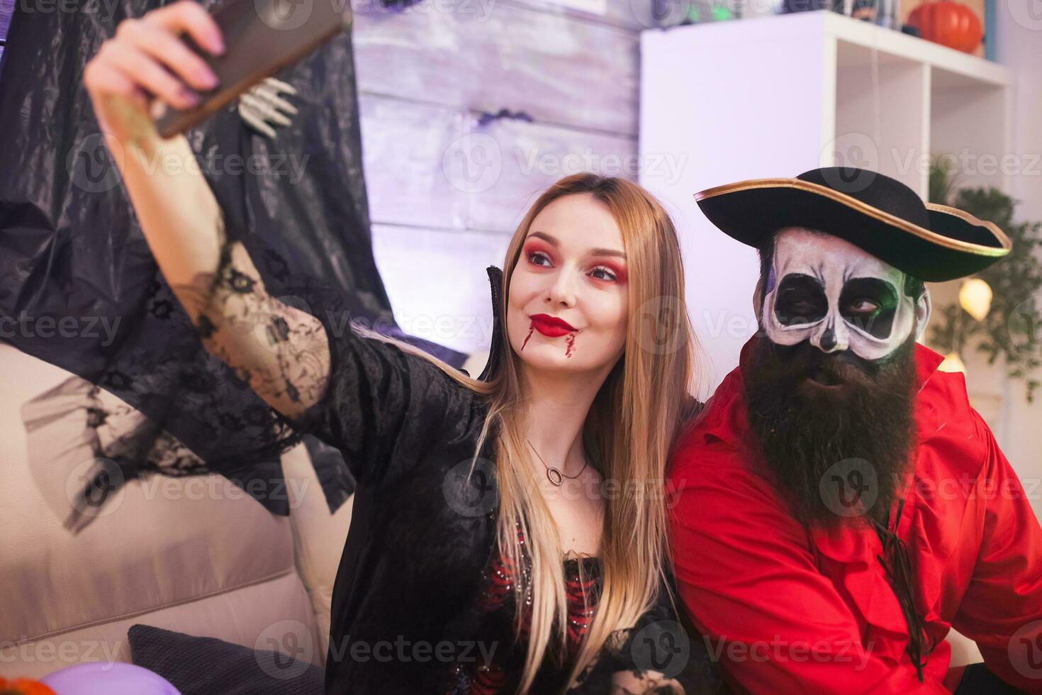 bäst vänner klädd upp tycka om medeltida pirat och vampyr kvinna tar selfie på halloween fest. foto