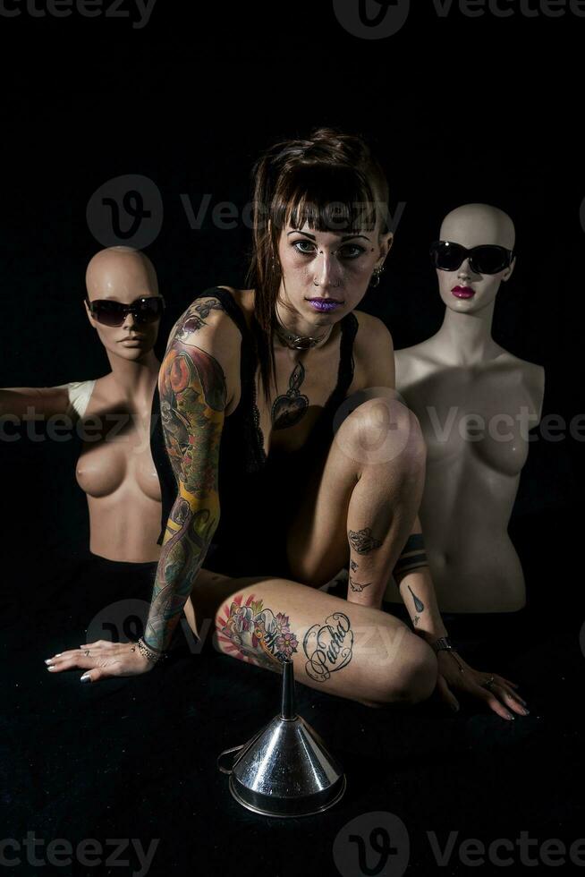 ung tatuerade kvinna tillsammans två skyltdockor i främre av en tratt foto