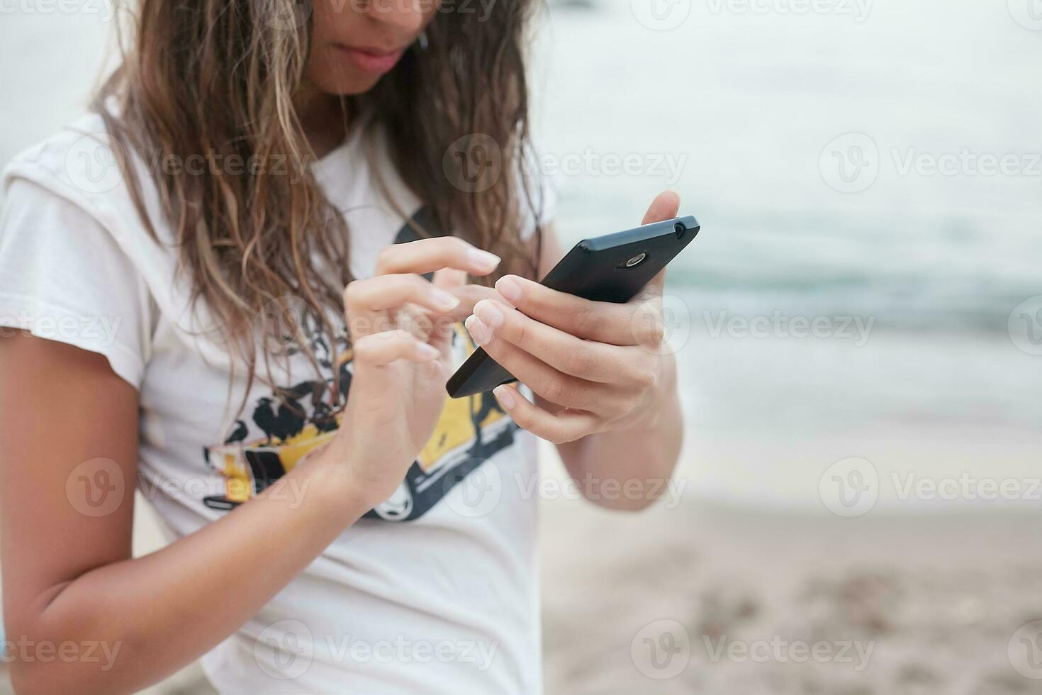 flicka med telefon på de strand foto
