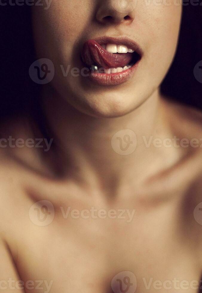 skön kvinna fastnar ut henne tunga och som visar genomträngande foto