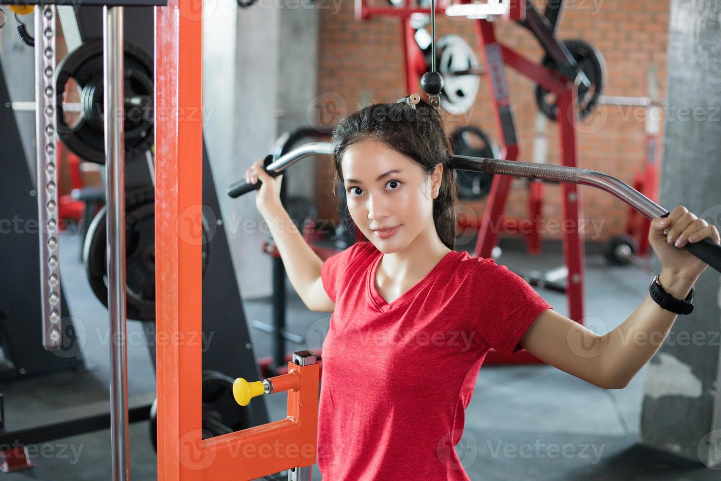 vacker muskulös fit kvinna som tränar byggande muskler och fitness kvinna gör övningar i gymmet. fitness - begreppet hälsosam livsstil foto