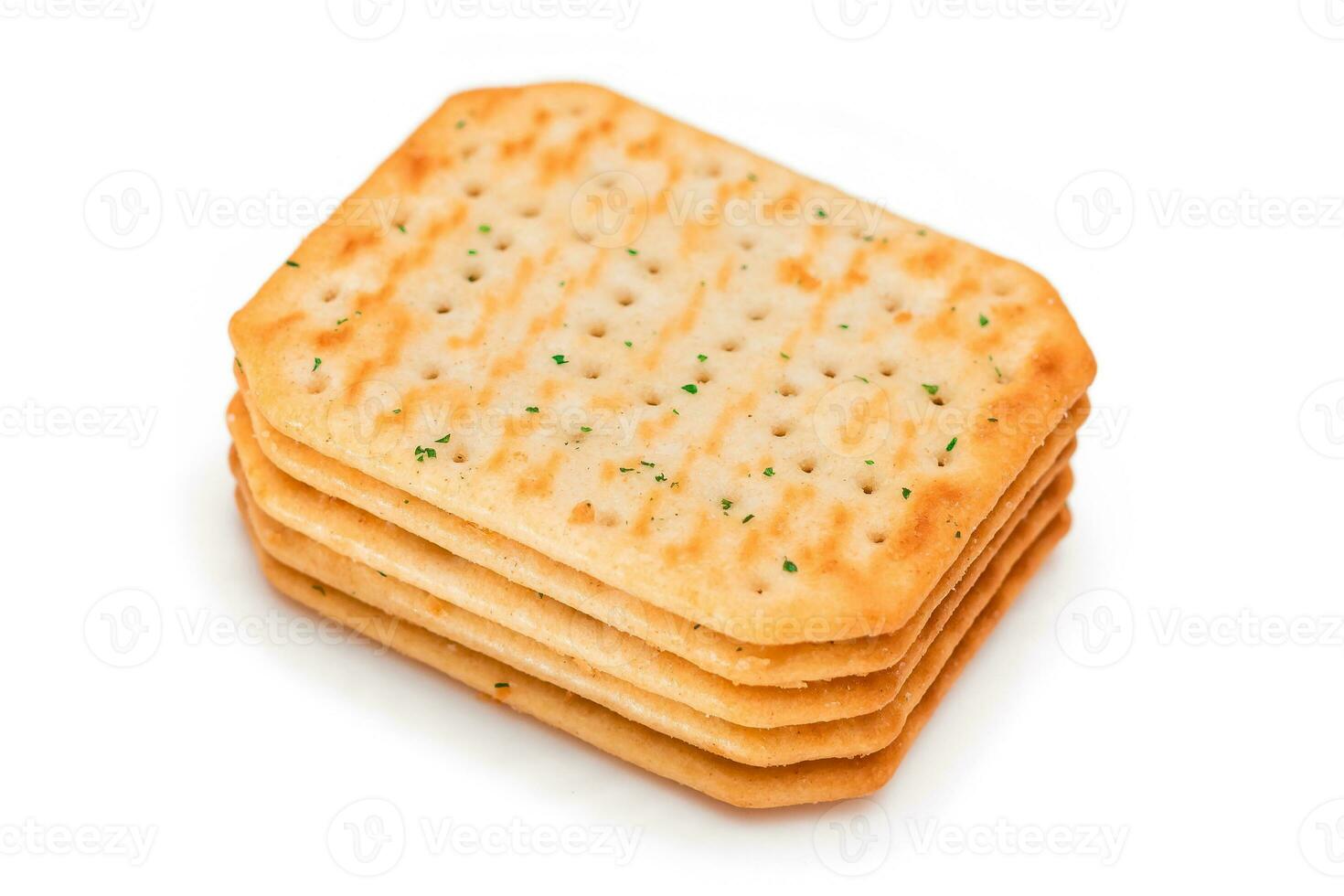 stack av Krispig saltade crackers med grönt isolerat på vit. lätt mellanmål isolering foto