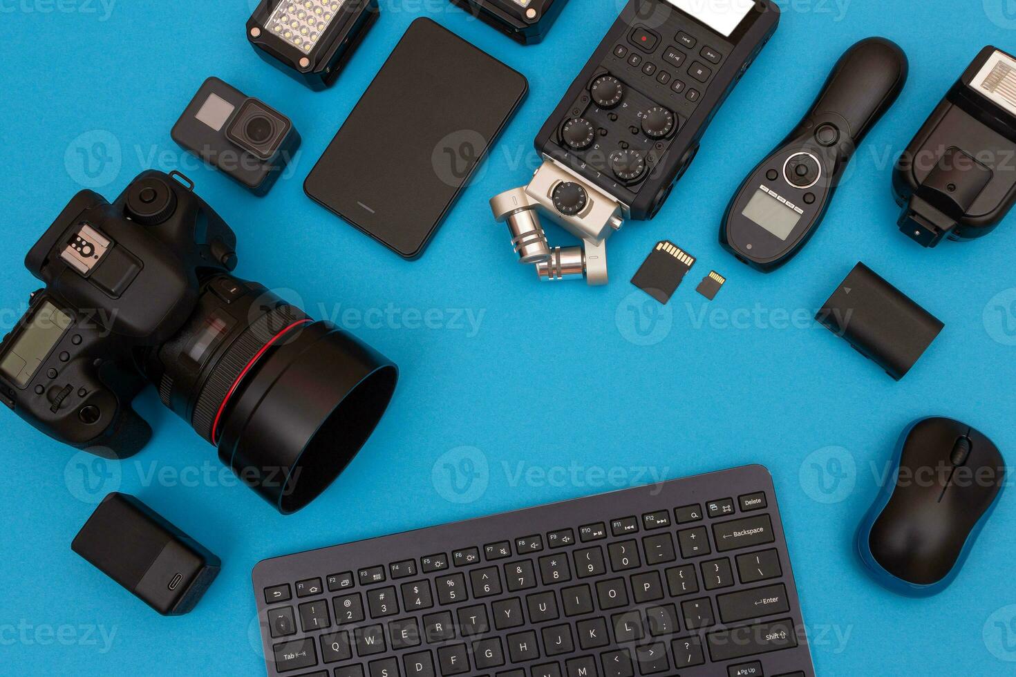 topp se av fotografens, videofotograf eller video bloggarens arbetsplats. digital gadgetar liggande på blå tabell platt lägga foto