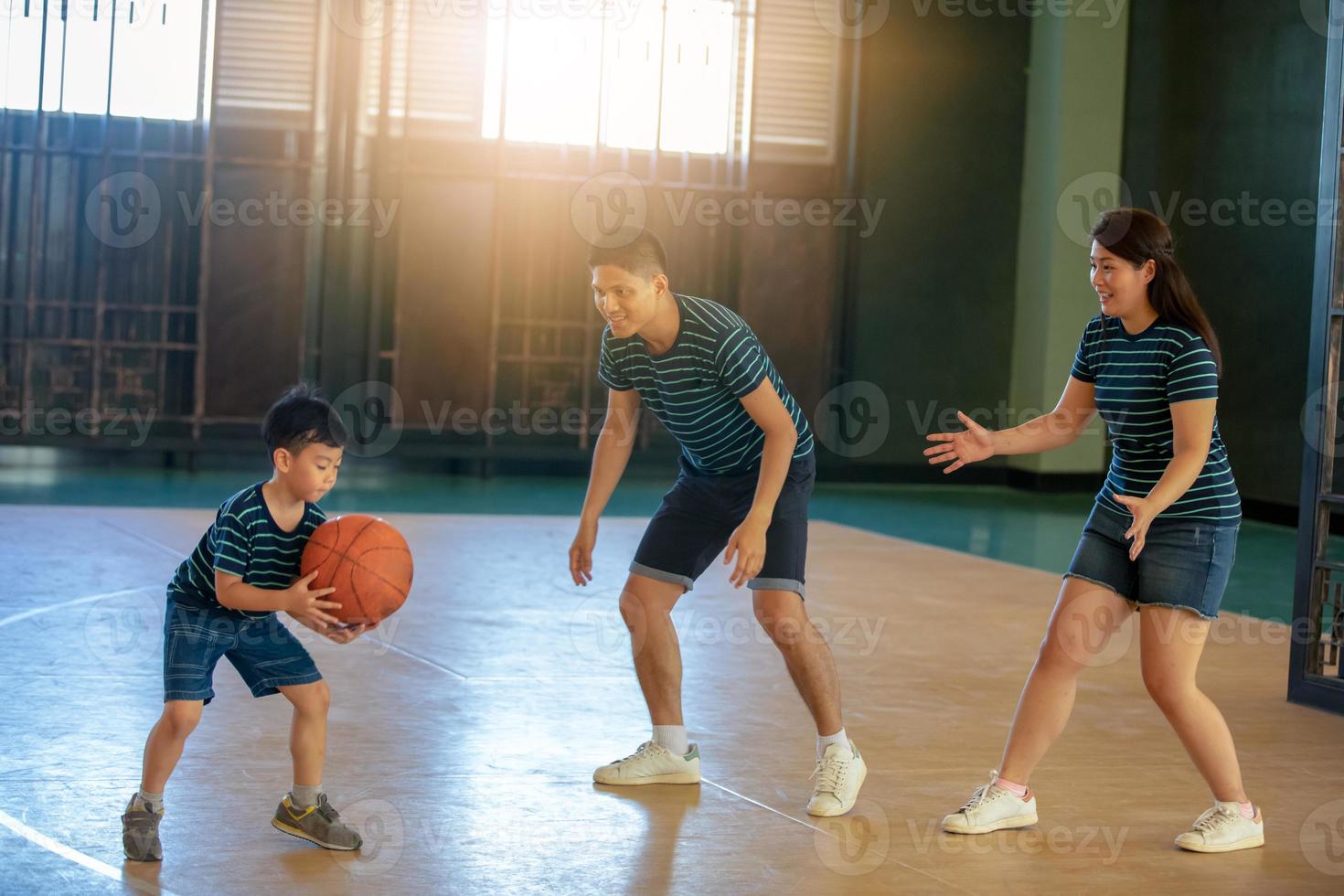 asiatisk familj som spelar basket tillsammans. lycklig familj som spenderar ledig tid tillsammans på semester foto