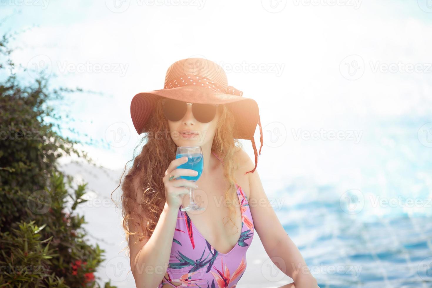 kvinnor bär bikini och dricker cocktails under den varma sommaren vid poolen. foto