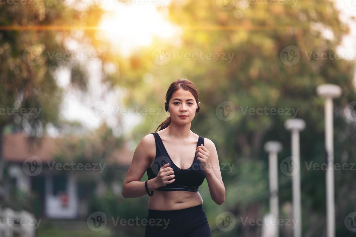 löpande kvinna. kvinnlig löpare joggar under utomhus på vägen. ung blandad tjej joggar foto