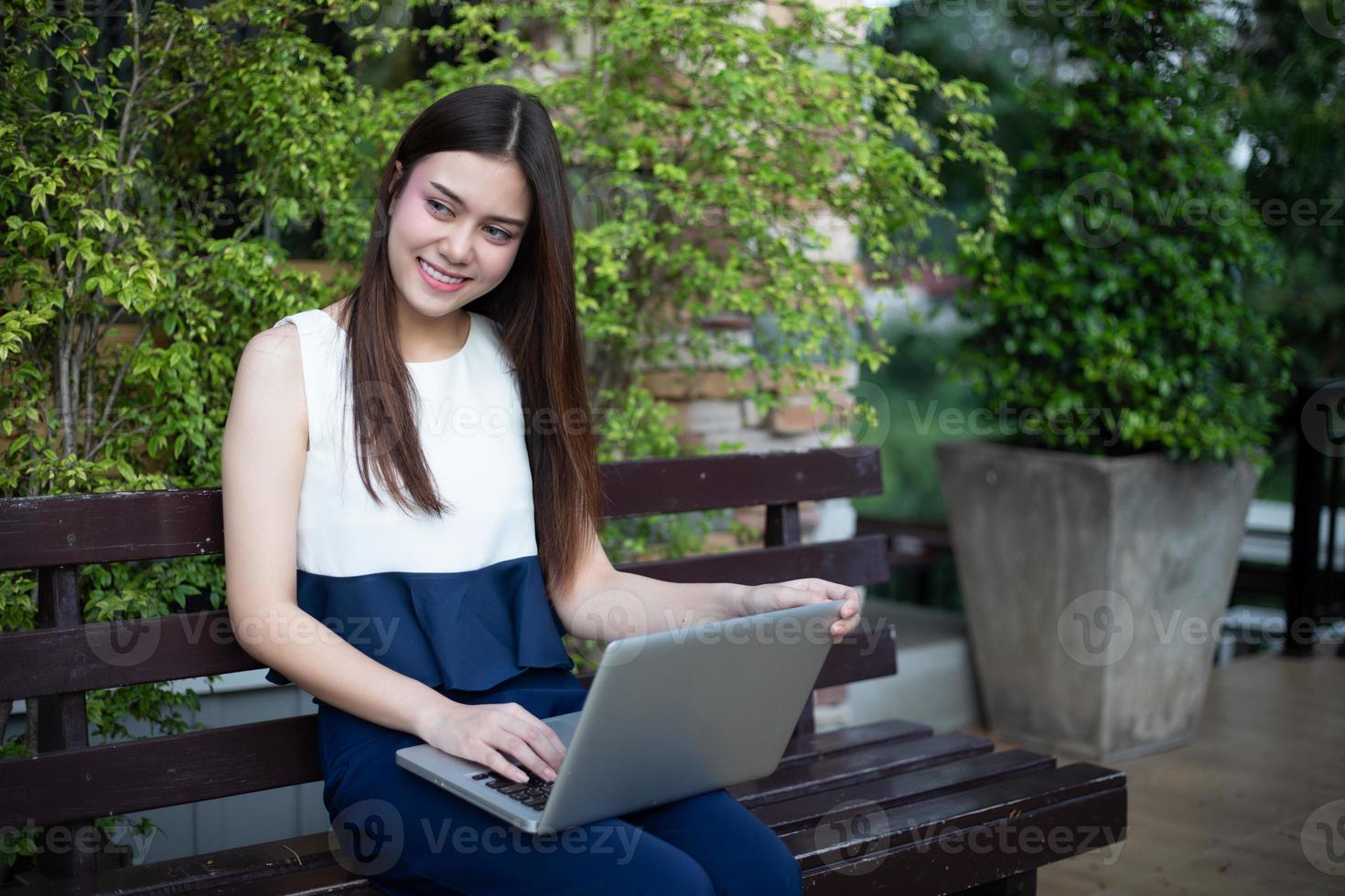 asiatiska affärskvinnor som använder anteckningsbok för att arbeta utomhus foto
