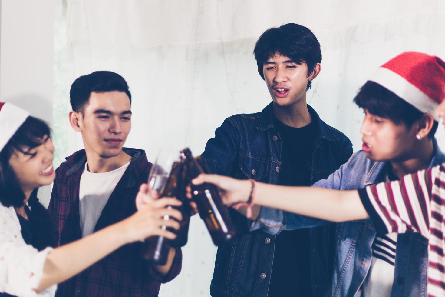 asiatisk grupp vänner som har fest med alkoholhaltiga öldrycker och ungdomar som njuter i en bar som rostar cocktails. mjuk fokus foto