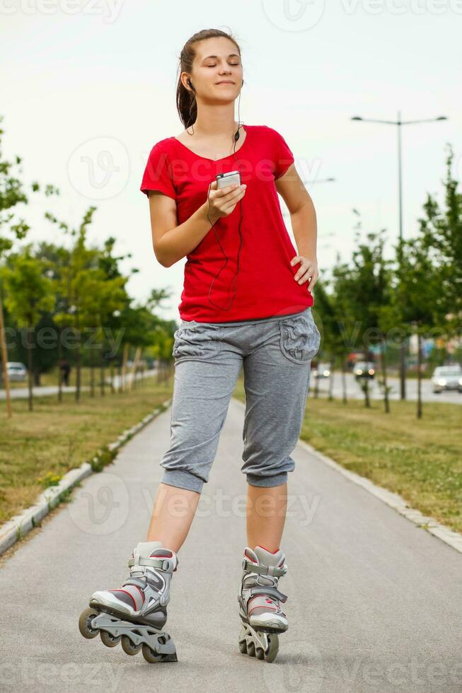 ung kvinna på vält skridskor lyssnande musik foto