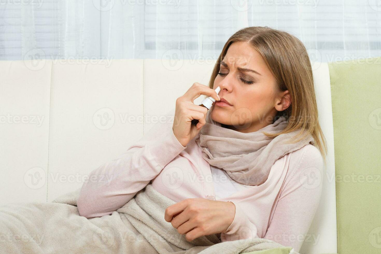 kvinna använder sig av nasal spray foto