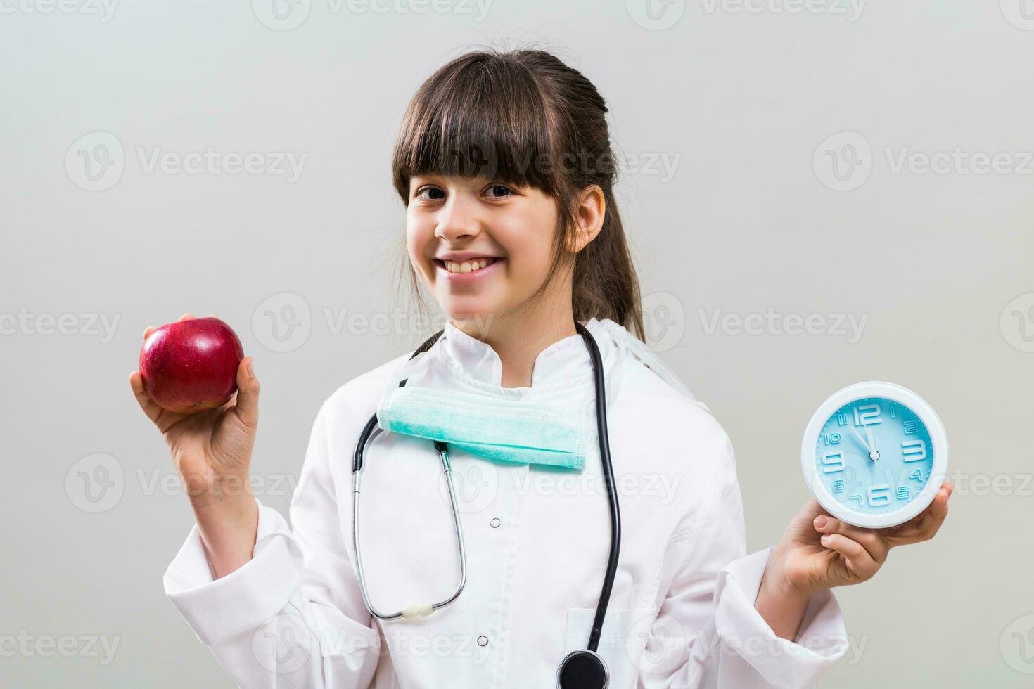 liten läkare är ger råd den där är tid till äta frukt förbi innehav äpple och klocka. foto