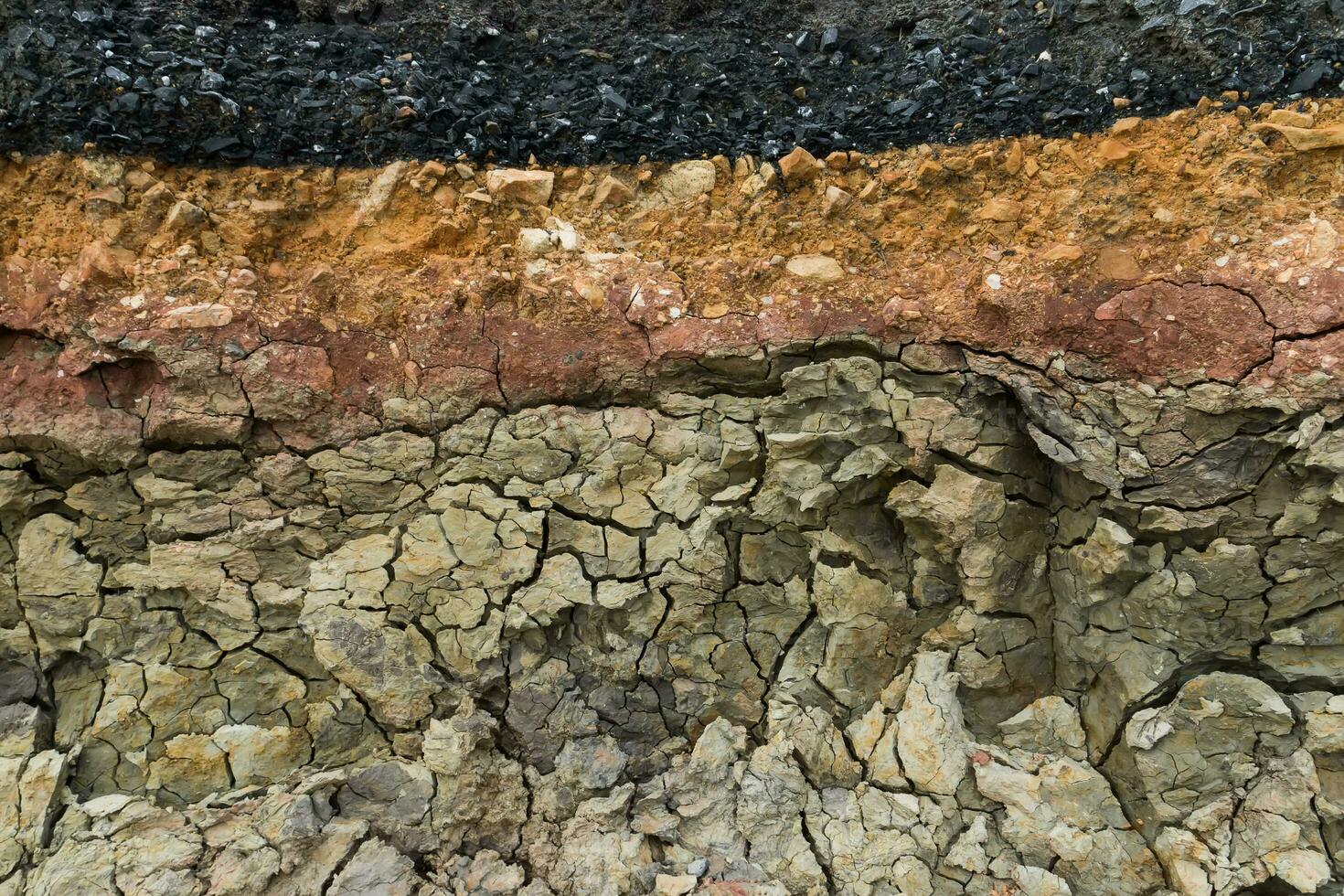 de lager av asfalt väg med jord och sten. foto