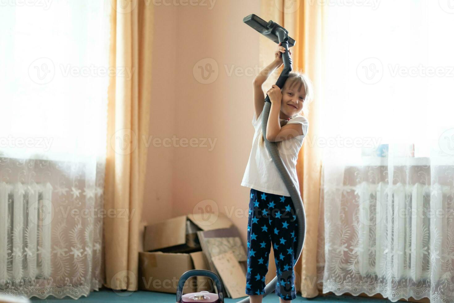 liten flicka rengöring golv med Vakuum rengöringsmedel foto