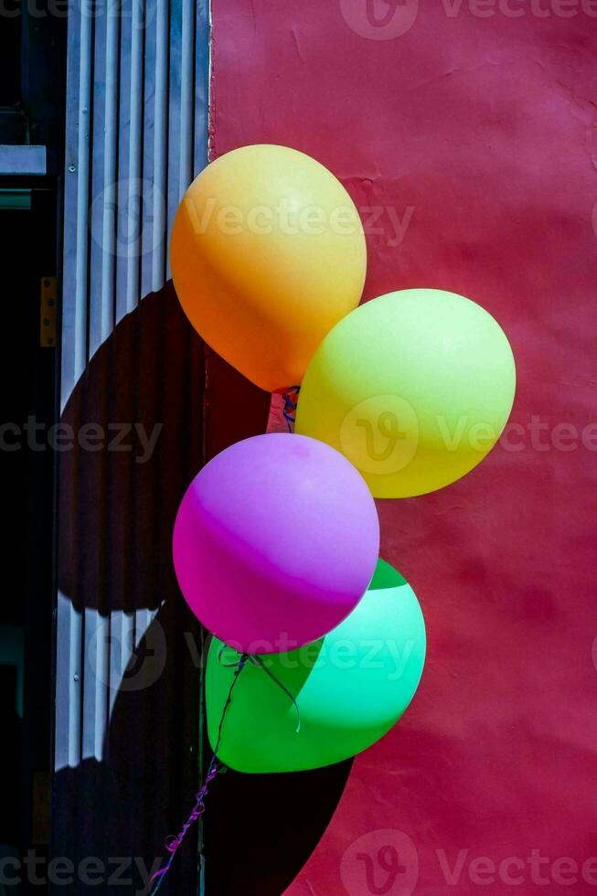 färgrik ballonger mot en röd vägg foto