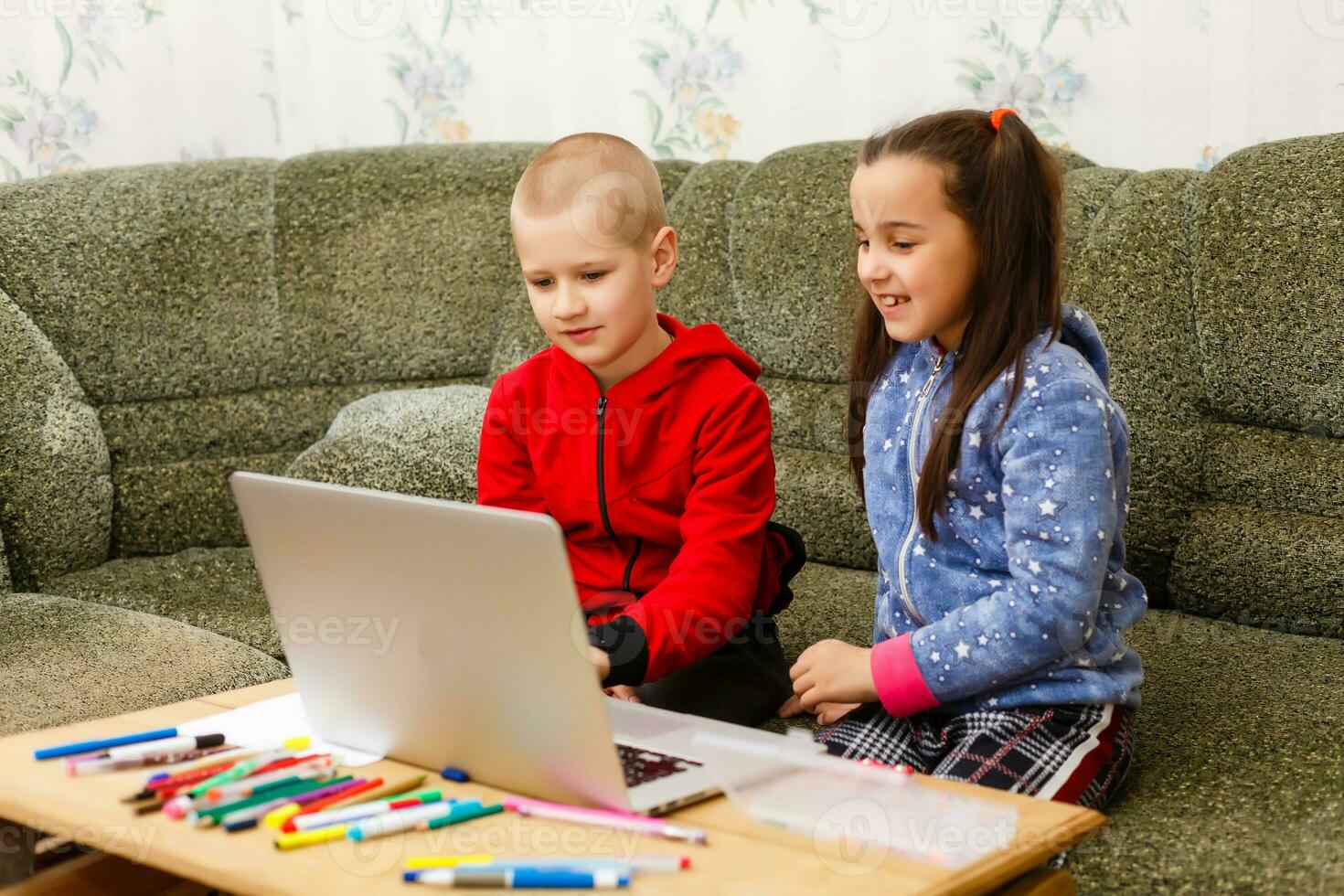 distans inlärning uppkopplad utbildning. skola pojke och flicka studerar på Hem med bärbar dator anteckningsbok och håller på med läxa. Sammanträde på en tabell foto