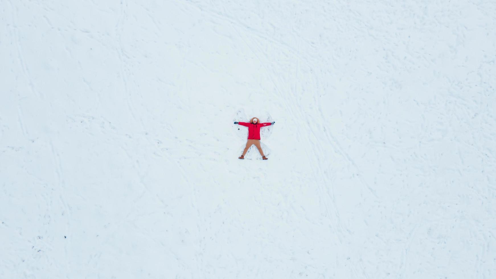 ovanifrån ovanifrån av mannen som gör snöängel foto