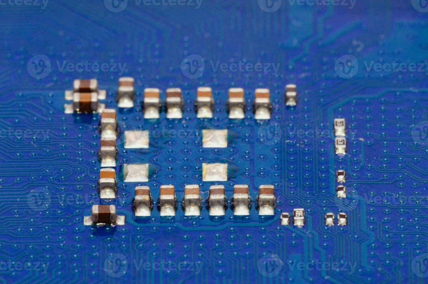 de elektronisk komponenter på en blå krets styrelse foto