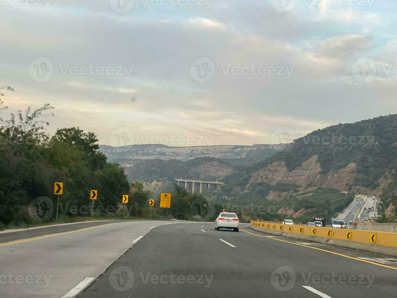 en bil körning ner de motorväg med bergen i de bakgrund foto