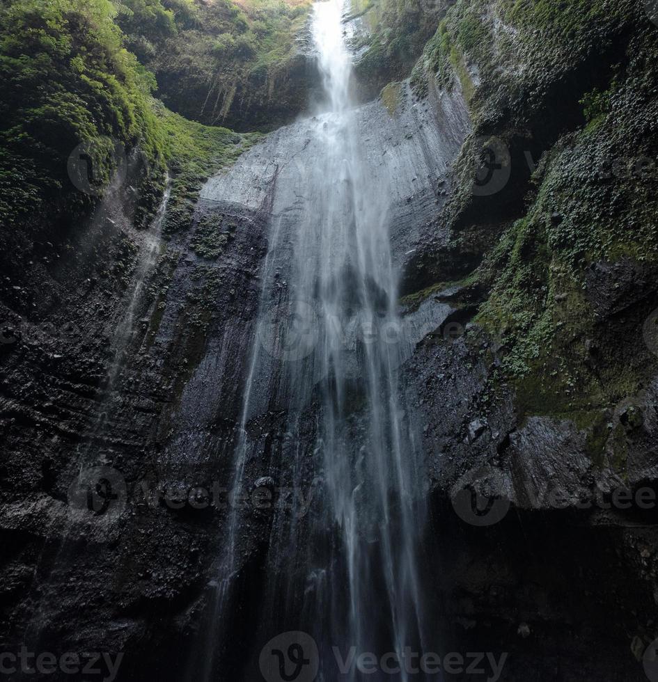 majestätiskt vattenfall som flödar på en stenig klippa i tropisk regnskog foto