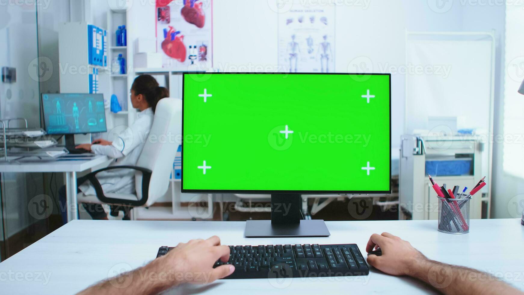 pOV av läkare hand arbetssätt på dator med grön skärm i sjukhus skåp. medicinsk läkare i klinik skåp arbetssätt skrivbordet med kopia Plats tillgängligt. foto