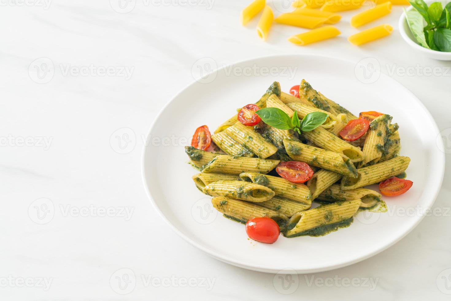 penne pasta med pestosås och tomater foto