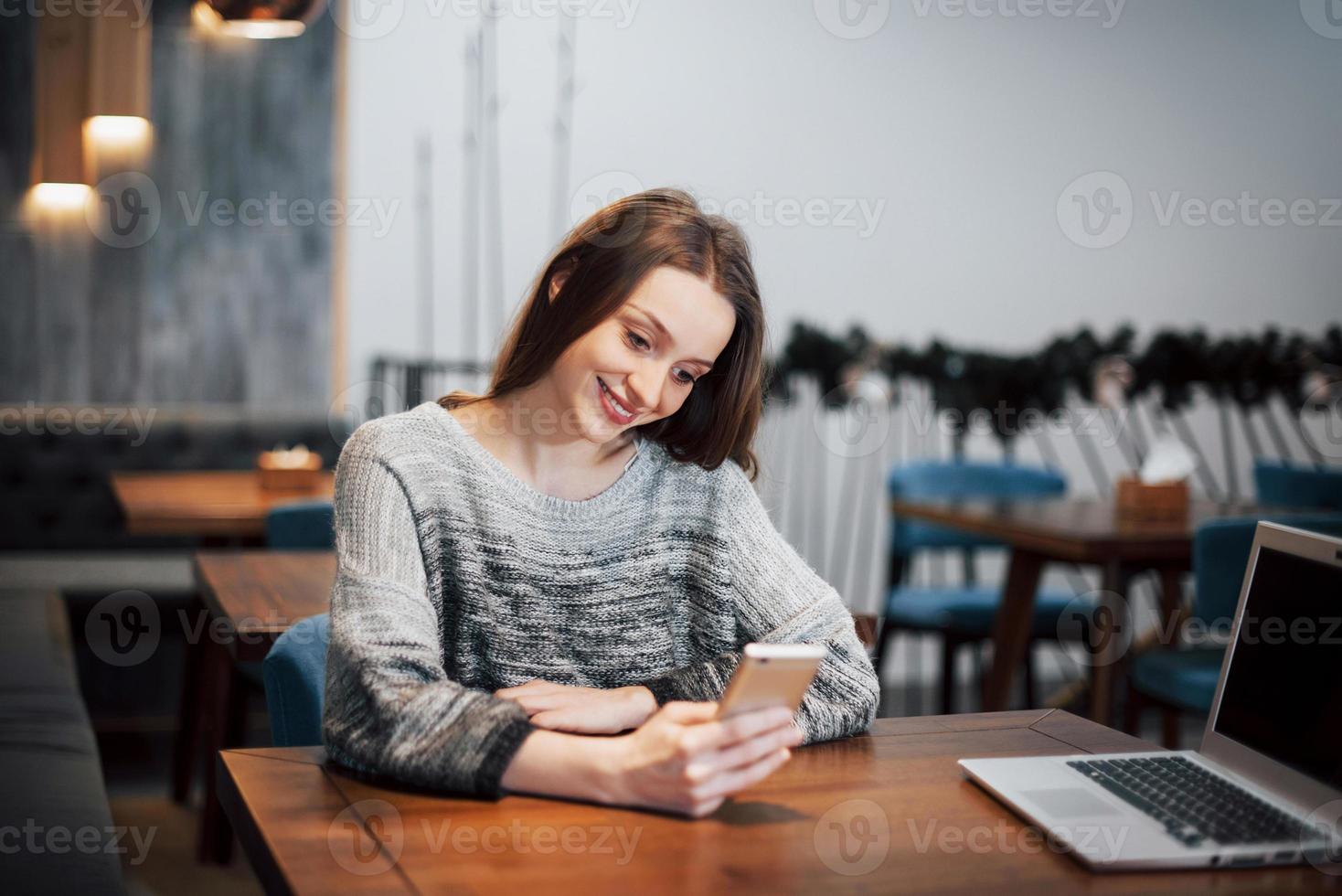 en attraktiv tjej med långt svart hår funderar över ett nytt projekt under en fikapaus som sitter vid ett bord i ett kafé foto